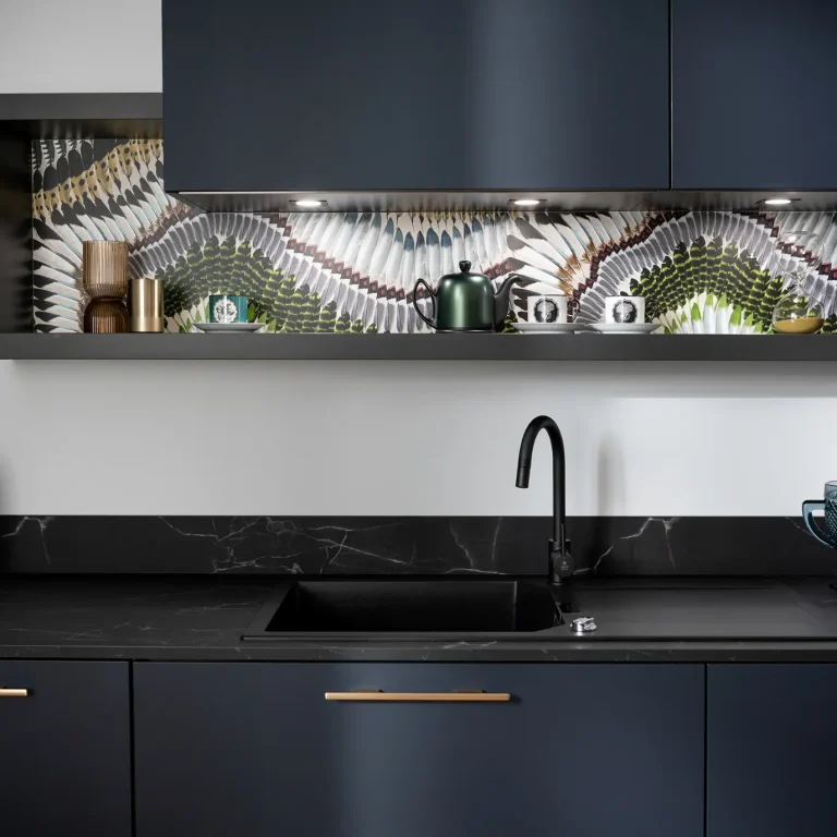 Navy kitchen with patterned stone splashback and black sink